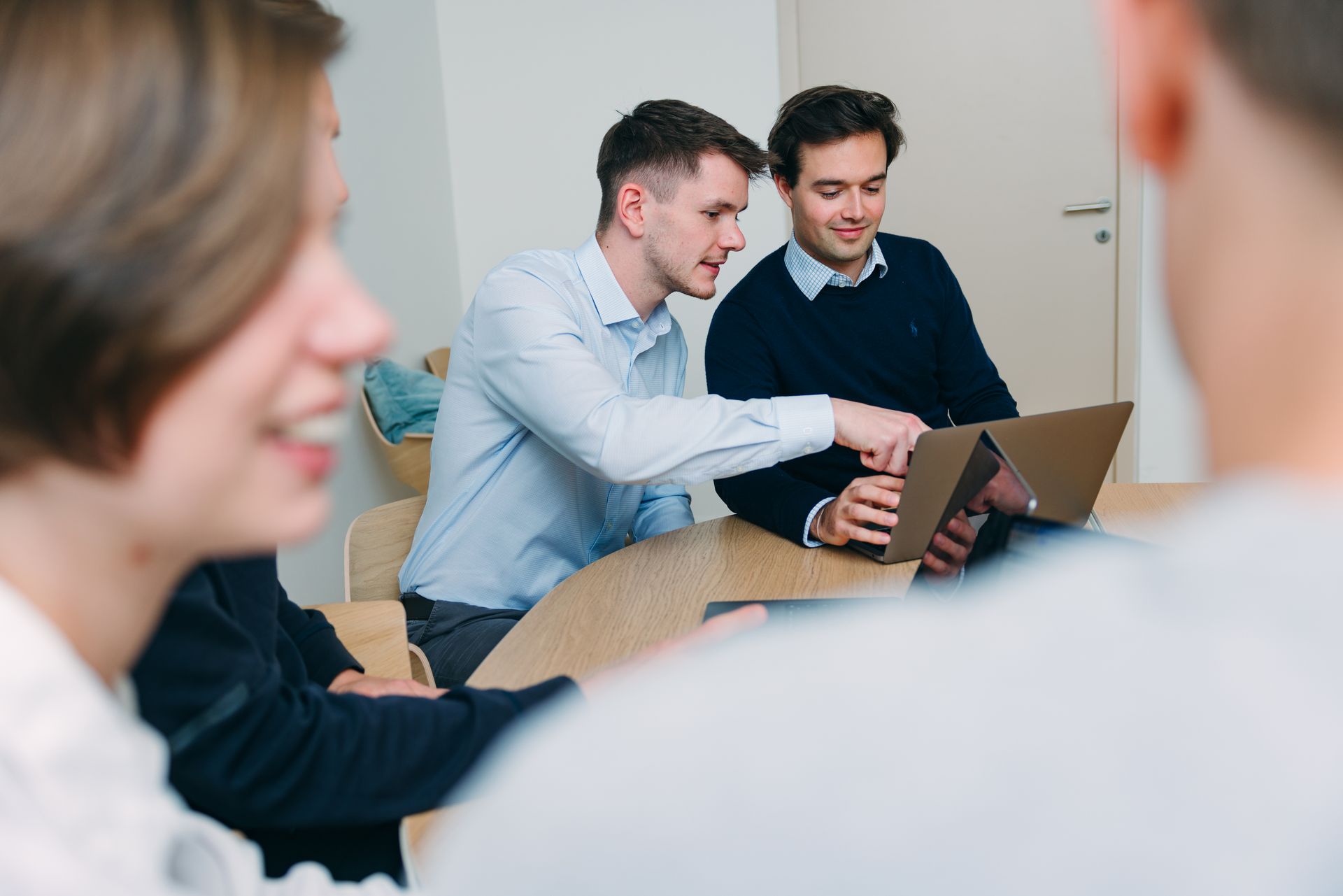 Bild auf dem 2 Personen zusammen in einem Meeting sind und auf einen Laptop schauen
